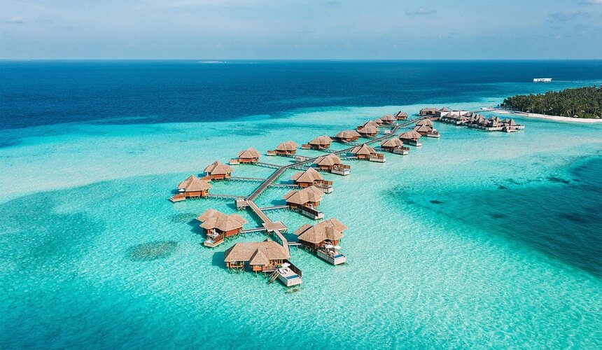 Overwater villas and crystal-clear ocean in a tropical Maldives setting
