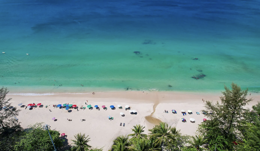 Vibrant beach scene with palm trees and parasails in Phuket, Thailand