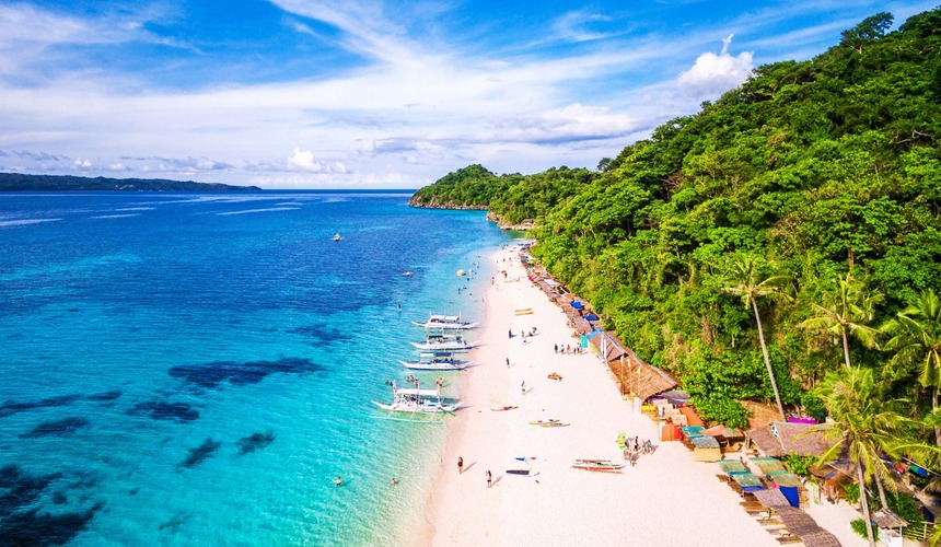 Palm-lined shore and powdery white sand at White Beach, Boracay, Philippines