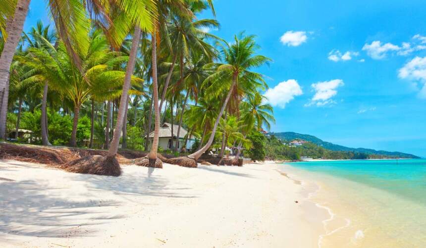 Tranquil Maenam Beach with calm waves and views of Koh Phangan in the distance.